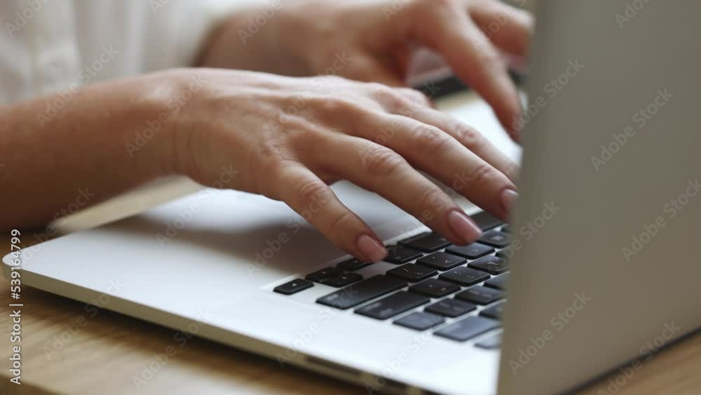 Freelancer working on a laptop from home, female hands in frame Freelancer working on a laptop from home, female hands in frame