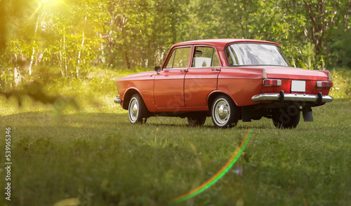Beautiful red retro car. Against the background of nature