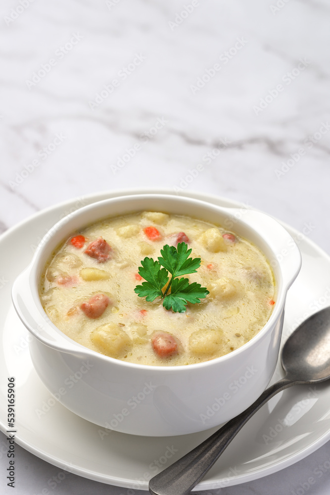 Close-up of a bowl of potato soup with vegetables and pieces of meat. Vertical shot from a high angle and copy space. Close-up of a bowl of potato soup with vegetables and pieces of meat. Vertical shot from a high angle and copy space.