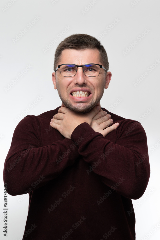 Handsome man wearing glasses over isolated background touching painful neck, sore throat from flu, cold and infection Handsome man wearing glasses over isolated background touching painful neck, sore throat from flu, cold and infection