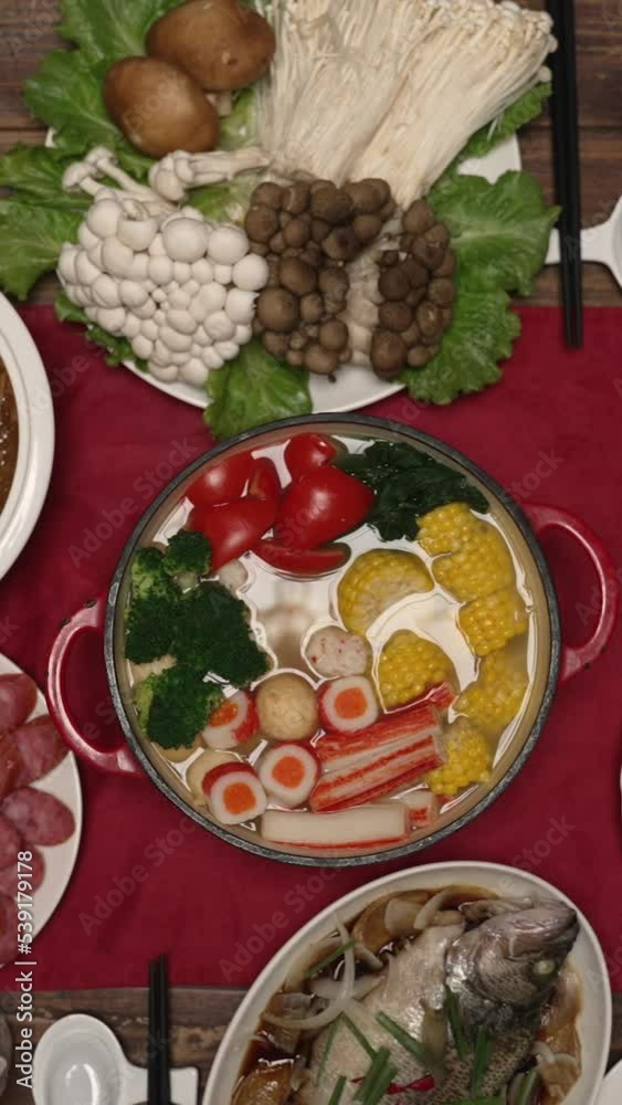 Vertical Screen: top angle view with zoom out various delicious dishes on the dining table in celebration of chinese lunar new year. Vertical Screen: top angle view with zoom out various delicious dishes on the dining table in celebration of chinese lunar new year.