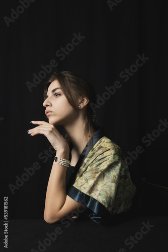 portrait of a beautiful woman with a pearl bracelet on a black background