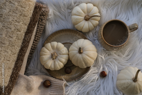 Autumn cozy composition. Autumn flat lay with a cup of coffee and white pumpkins on a white background. Flat lay, top view.