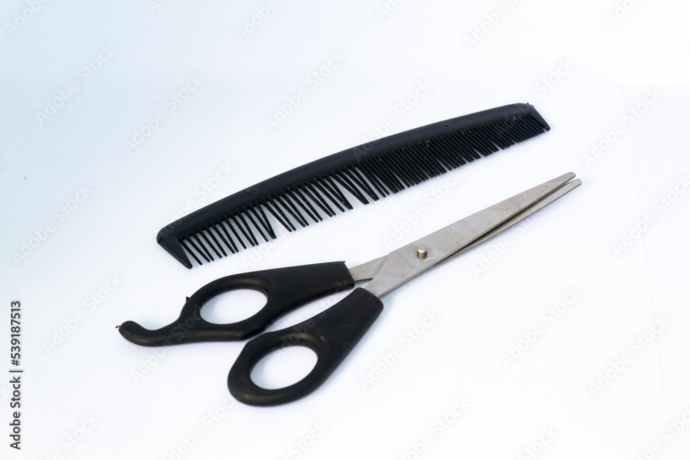 One black comb and scissors. Isolated on white background. One black comb and scissors. Isolated on white background.