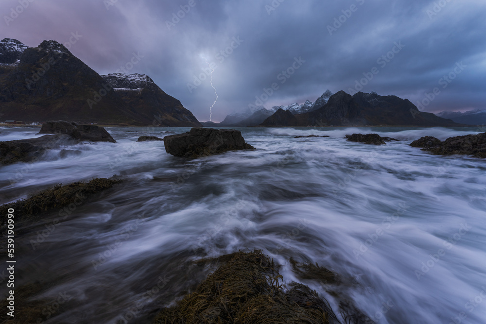 Lightning flashing above stormy sea on cloudy day