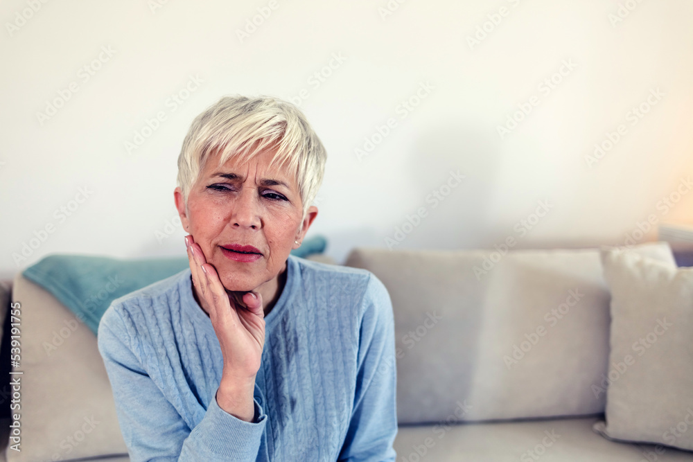 Photo of depressed ill mature woman having toothache and touching cheek. Mature woman suffering from tooth pain, caries. Gray hair female suffering from toothache, closeup. Photo of depressed ill mature woman having toothache and touching cheek. Mature woman suffering from tooth pain, caries. Gray hair female suffering from toothache, closeup.
