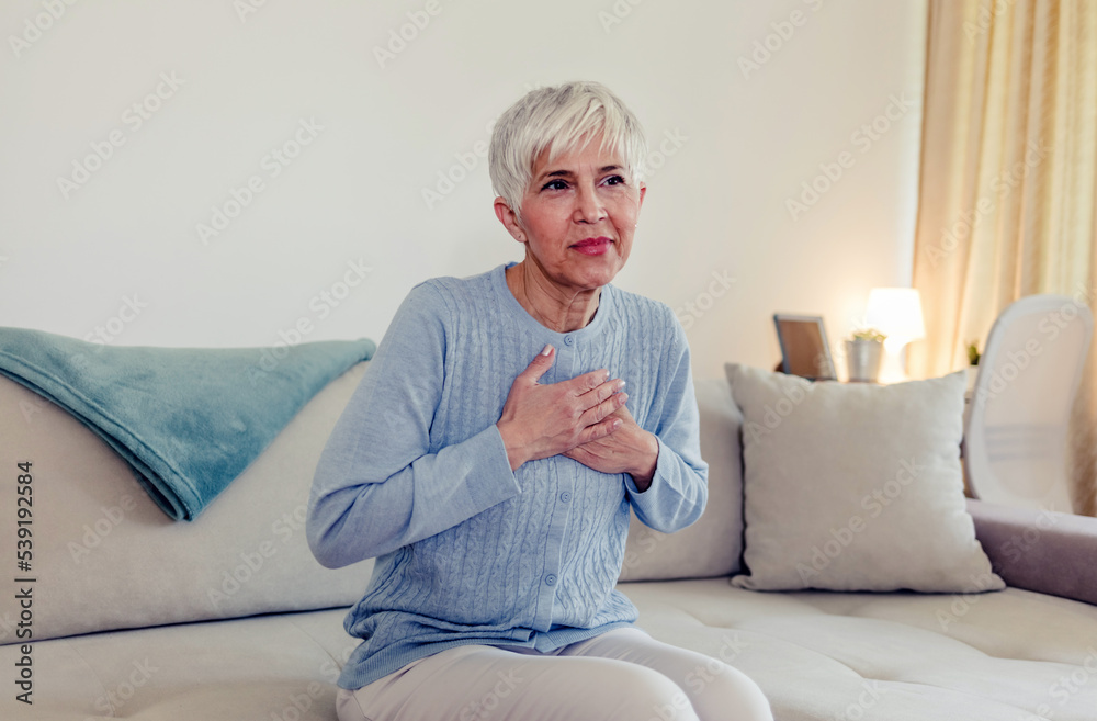 Upset stressed mature middle aged woman feeling pain ache touching chest having heart attack. Sad worried senior older lady suffers from heartache at home, infarction or female heart disease concept. Upset stressed mature middle aged woman feeling pain ache touching chest having heart attack. Sad worried senior older lady suffers from heartache at home, infarction or female heart disease concept.