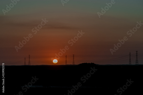 Por do sol e torres de energia