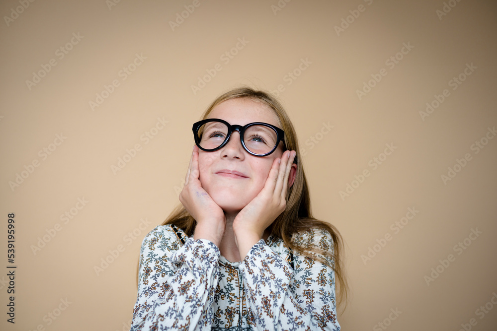 cool schoolgirl with black glasses in front of brown background cool schoolgirl with black glasses in front of brown background