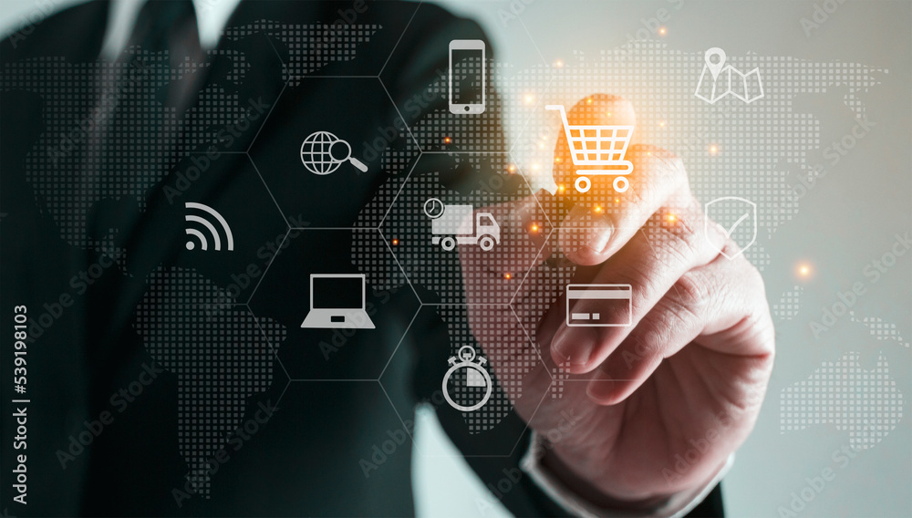 Businessman pointing finger at shopping cart icon online shopping concept online trading. Businessman pointing finger at shopping cart icon online shopping concept online trading.