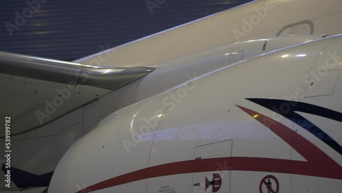 Close Shot of a Brand New Airplane Standing in a Aircraft Maintenance Hangar. Business plane jet on parking. High quality FullHD footage