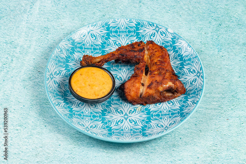 bbq chicken leg piece served in a dish isolated on background side view photo