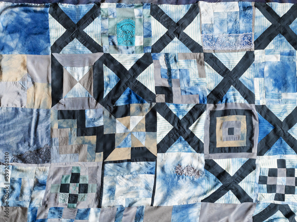 surface of handsewn patchwork quilt from pieces of various silk