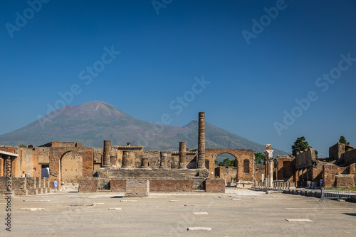 The ruins of Pompeii with a clear blue sky over Mount Vesuvius in Italy. photo