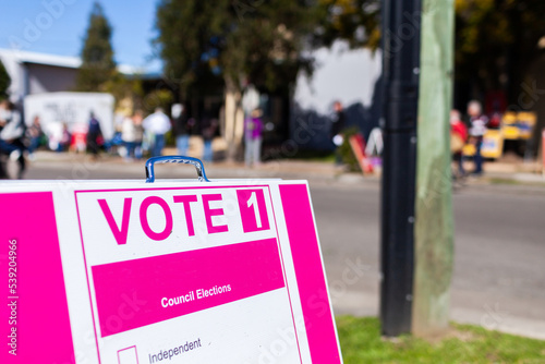 Vote 1 sign at local council election with party volunteers in background photo