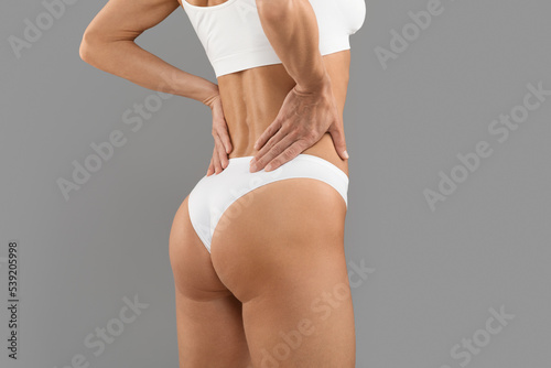 Rear View Of Sporty Female In White Underwear Demonstrating Her Perfect Buttocks