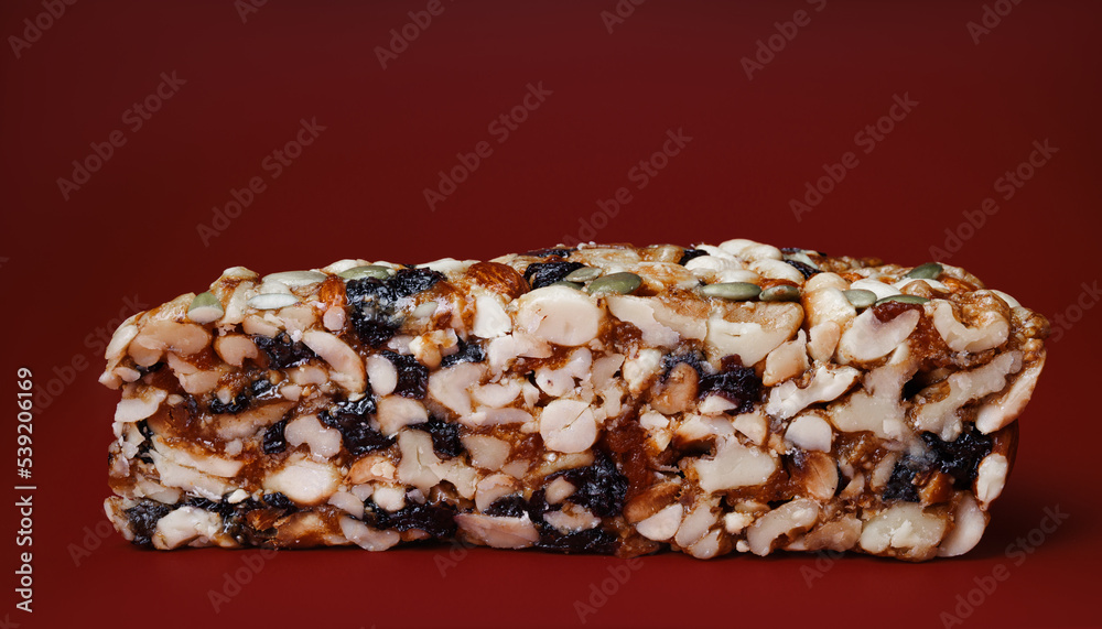 Kozinak from various nuts with dried fruits on a red background. Kozinak from various nuts with dried fruits on a red background.