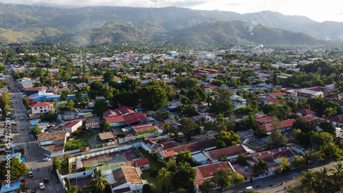 Daily life, activities and sights of Dili, Timor Leste in Southeast Asia, panoramic view of red tinned roof houses, tree lined streets and hills in the distance