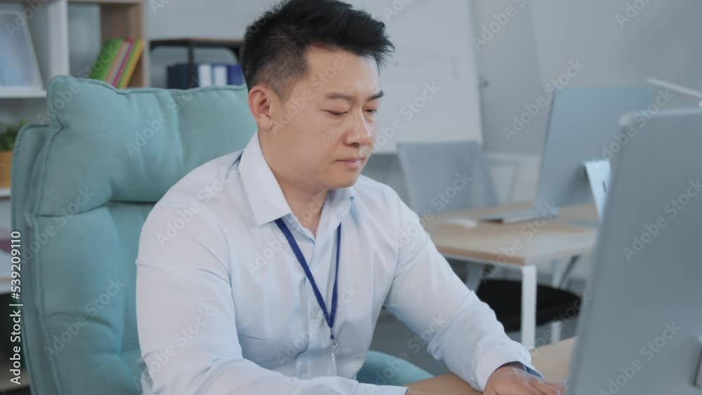 Portrait of shocked and upset Asian man in formal clothes sitting at workplace. Frustrated office worker looking at screen of computer. Dismissal from work. Staff reduction. Bad news. Indoors Portrait of shocked and upset Asian man in formal clothes sitting at workplace. Frustrated office worker looking at screen of computer. Dismissal from work. Staff reduction. Bad news. Indoors