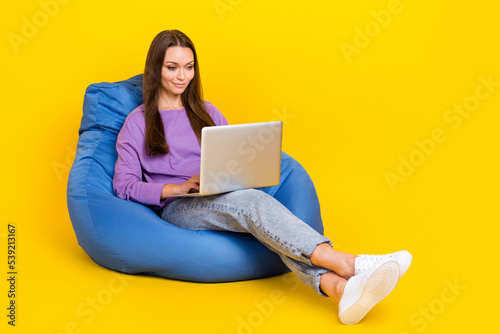 Full length photo of concentrated lady sit comfort chair reading news chatting colleagues empty space isolated on yellow color background