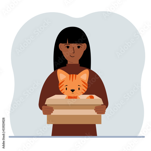 A woman is holding a cardboard box with a beautiful ginger cat. The concept of rescue, help and care for pets.