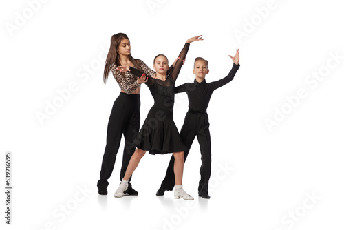 Dance class with personal coach. Two kids, school age girl and boy in black stage costumes studying to dance isolated on white background. Art, education, dance, music, studying © master1305