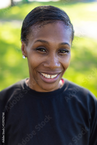 Portrait of smiling young black female looking up to camera 