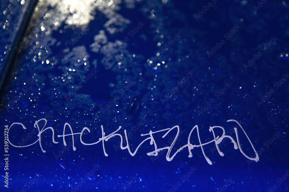 A blue garbage can lid wet with rain at night, white graffiti, raindrops, nobody A blue garbage can lid wet with rain at night, white graffiti, raindrops, nobody