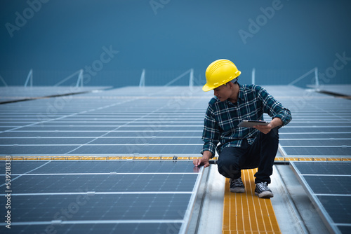 Wallpaper Mural Asian electrical engineer in safety helmet and uniform using laptop checking solar panels. Male technician at the solar station. Torontodigital.ca