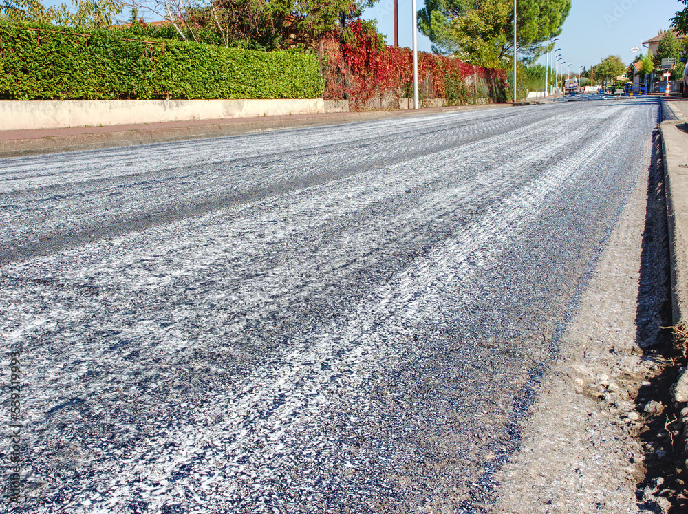 Small town road grading, street shows surface grooves in preparation for reasphalting Stock