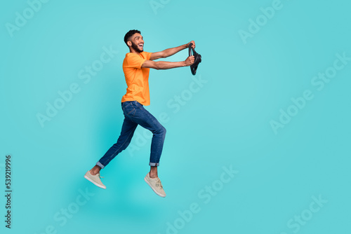 Full size profile photo of crazy cheerful person arms hold wheel jump hurry rush isolated on teal color background