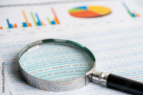 Magnifying glass on chart graph spreadsheet paper. Financial development  Banking Account  Statistics  economy  Stock exchange trading  Business office company meeting concept.