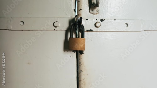 Camera Zoom Out. the lock on the white door. white iron door with an old lock.  