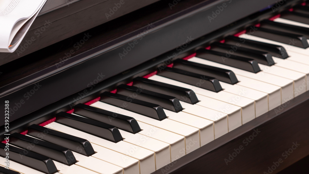 Music composition with piano keyboard. Electronic piano with sheet music. Piano lesson. Music education. Selective focus Music composition with piano keyboard. Electronic piano with sheet music. Piano lesson. Music education. Selective focus