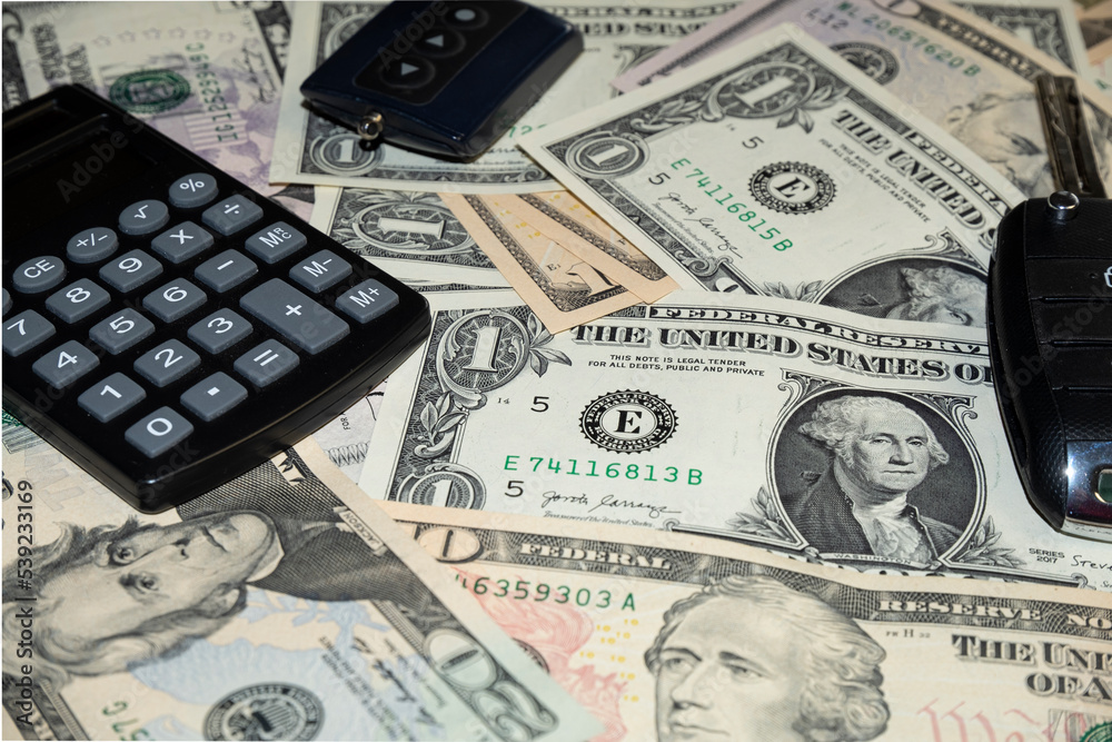 car keys and canculator on the photo of money. calculate the cost of a car trip car keys and canculator on the photo of money. calculate the cost of a car trip