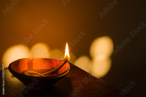 diya or earthen oil lamp lit with flame during diwali celebration in india. deepabali or kali puja is celebrated across india as a major festival of light. photo