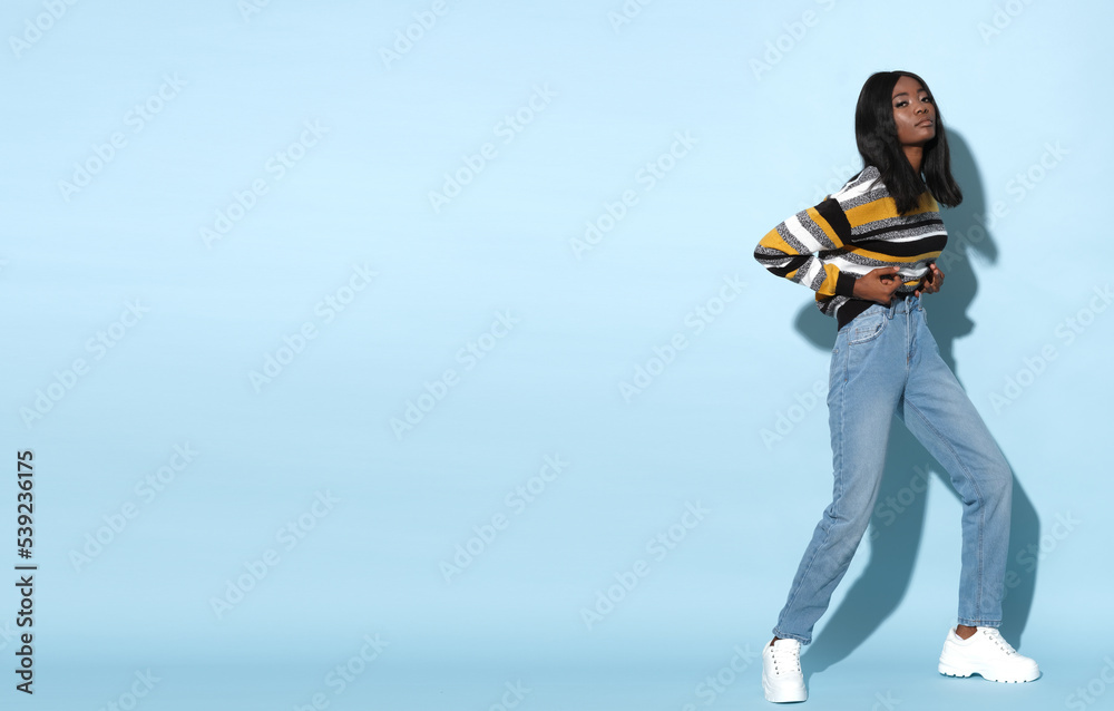 Naklejka premium Fashionable African fashion model on blue background.