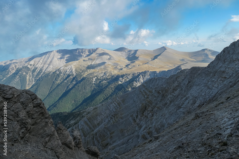Panoramic view from cloud covered mountain summit Mytikas Mount Olympus, Mt Olympus National Park, Macedonia, Greece, Europe. Home of the Ancient Greek gods. Hiking trail from Skala, Skolio, Stefani