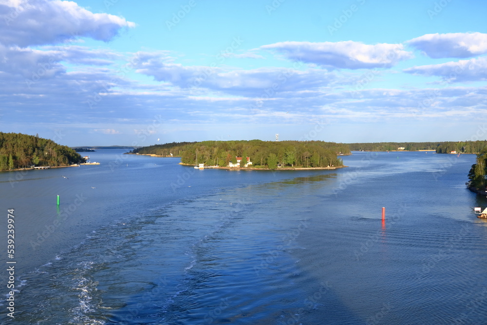 Beautiful scenery of natural environment of Turku archipelago surrounded with the greenery of pine trees and water surface with tall water grass and local sailing boats
