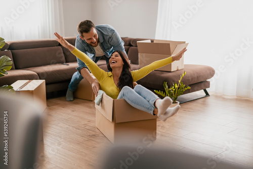 Foto Happy couple is having fun with cardboard boxes