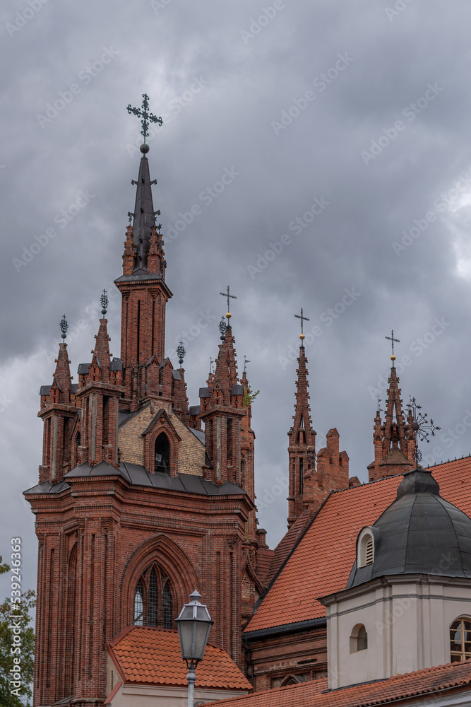 Obraz premium St. Anne's Church in Vilnius, with hevy cloudy sky on the background.