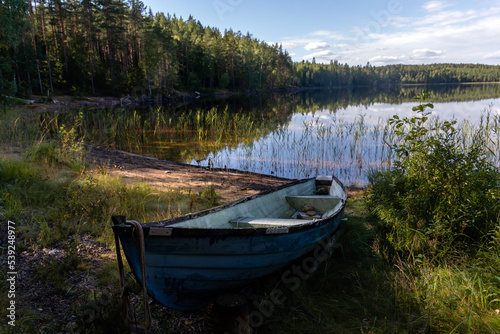 Fototapeta Naklejka Na Ścianę i Meble -  Old blue fiberglass boat on sandy beach in Repovesi National Park, Finland