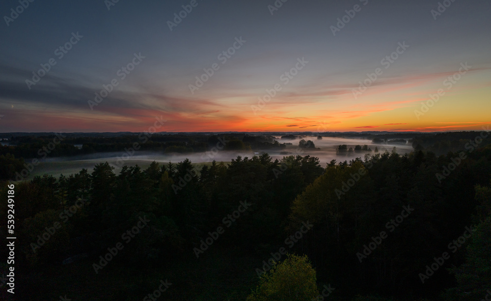 An autumn evening in the fields of Latgale is decorated with fog and sunset.