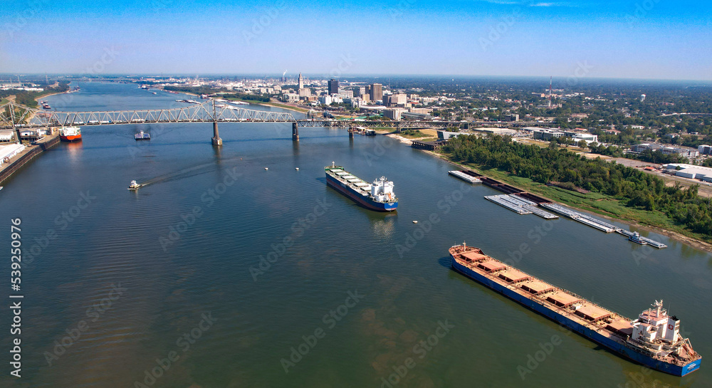 Baton Rouge Louisiana Mississippi River Bridge cargo ships tug boats levee state captiol in city high shot afternoon