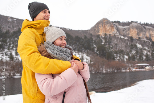 Happy people, man and woman hugging outdoor and have fun with snow
