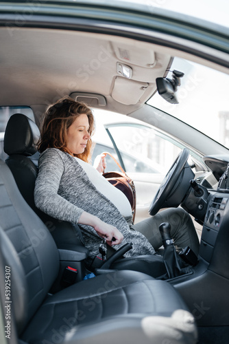 Calm pregnant redhead woman driving. © Maria