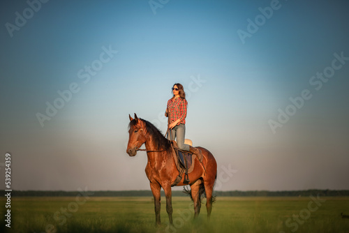 Young beautiful dark-haired girl on a horse. There is artistic noise. © shymar27