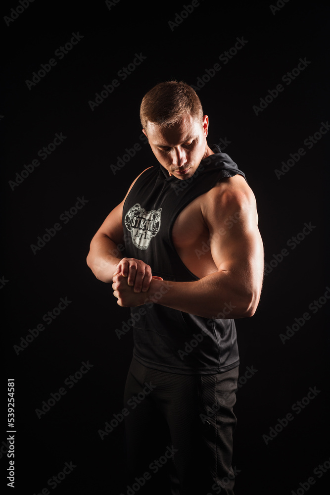 portrait of an athlete who shows his muscles on a black background