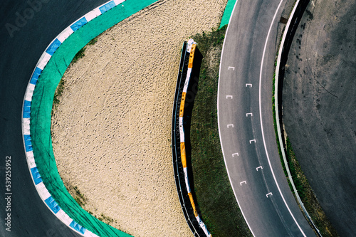 Aerial top down drone view of a racing track with tight turns and hairpins