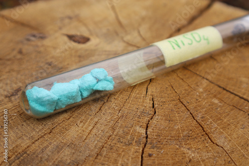 Pieces of toxic blue nickel sulfate in a test tube, a substance used as an ingredient in a fungicide mixture and to make battery electrolytes.